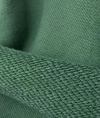A close up image of a green colour french terry knit fabric roll
