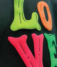 A close up image of a t shirt with a colourful 3D puff print