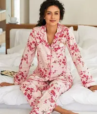 A photo of a woman wearing comfortable pajama set in a white and red floral pattern design